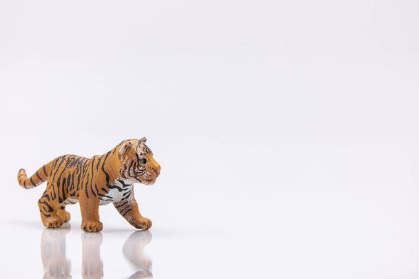 白い背景に隔離されたプラスチック製の赤ちゃん虎のおもちゃのクローズアップ - 写真・画像