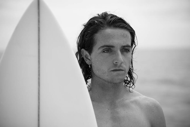 Retrato preto e branco do jovem surfista com prancha branca
 - Foto, Imagem