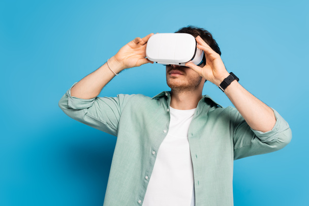 young man using vr headset on blue - Photo, Image