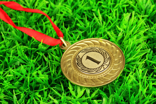 Medalha de ouro no fundo da grama
 - Foto, Imagem