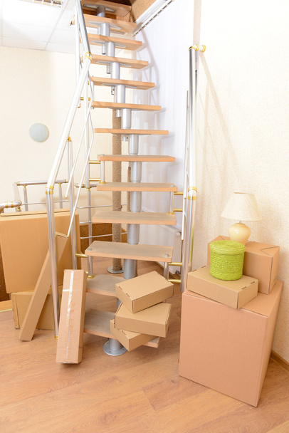 Montón de cajas de cartón cerca de escaleras: concepto de casa móvil
 - Foto, imagen