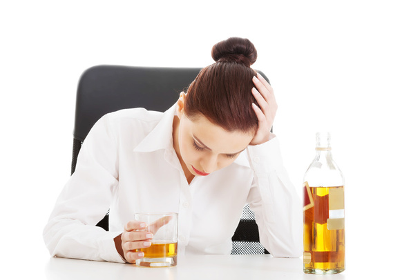 Young beautiful business woman with glass of whisky or rum. - Foto, Bild