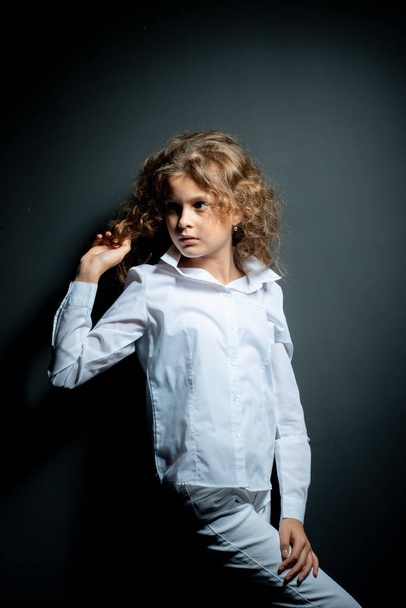 adorable preteen girl in white shirt posing on black background - Фото, изображение