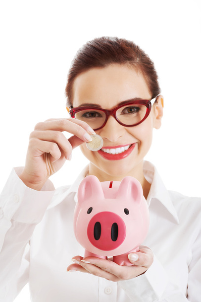 Beautiful business woman with coin and piggy- bank. - Фото, зображення