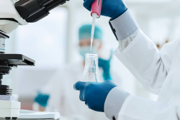 close up. scientist examining a liquid in a laboratory flask. - Zdjęcie, obraz