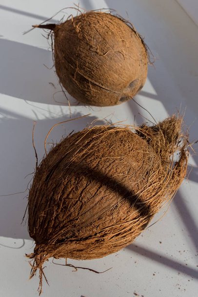 Tropische Kokosnuss auf hellem Hintergrund. Kokosnüsse sind für ihre Vielseitigkeit bekannt, die von Lebensmitteln bis hin zu Kosmetika reicht.. - Foto, Bild