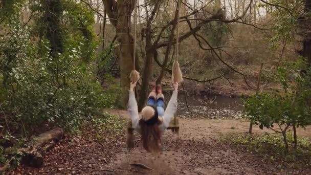 Giovane donna che oscilla su una casa fatta altalena nel bosco
 - Filmati, video