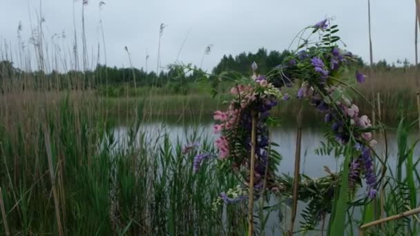 Věnec pestrobarevných divokých květin se houpe ve větru. Lesní jezero na oblačném letním dni na Ukrajině. - Záběry, video