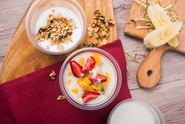 Tahta bir masada çilekli lezzetli granola yoğurdu. Üst Manzara. sağlıklı kahvaltı yemekleri - Fotoğraf, Görsel