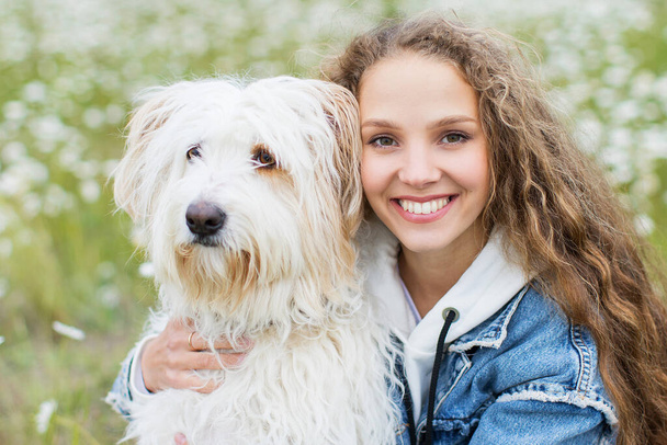 Portrait of a young beautiful woman with dog outdoors. Pets concept. - Foto, imagen