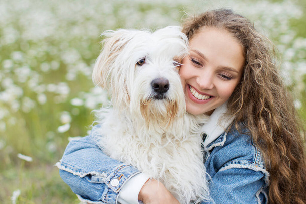 Portrait of a young beautiful woman with dog outdoors. Pets concept. - Foto, imagen