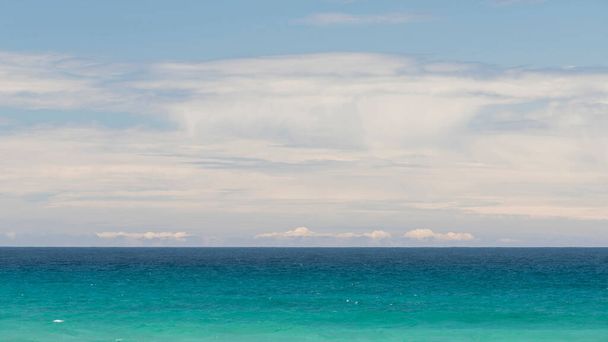 Minimalistinen merimaisema, jossa on turkoosi vesi ja pilvinen taivas - Valokuva, kuva