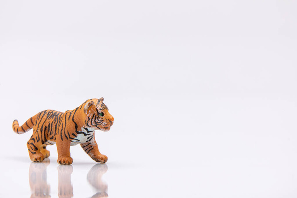 primo piano di un giocattolo di plastica tigre bambino isolato su uno sfondo bianco - Foto, immagini