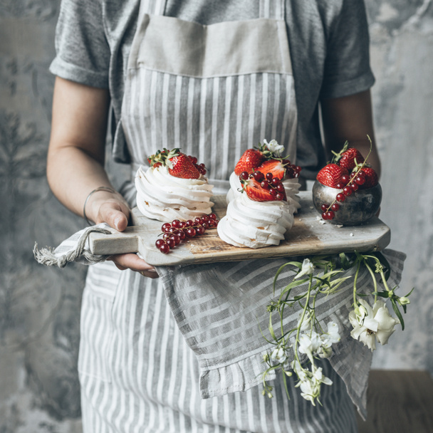 Meringue dessert with red berries is served on a wooden Board. - Photo, Image