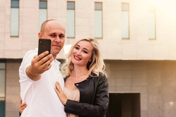 Portrait of a man and woman smiling while taking selfie - Fotografie, Obrázek