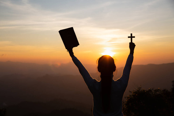 Mãos de uma mulher cristã segurando uma bíblia e cruz enquanto reza a Deus, crenças religiosas, espaço de cópia
. - Foto, Imagem