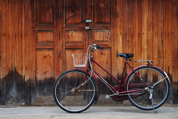 Классический велосипед парковка перед деревянной дверью и стеной
. - Фото, изображение