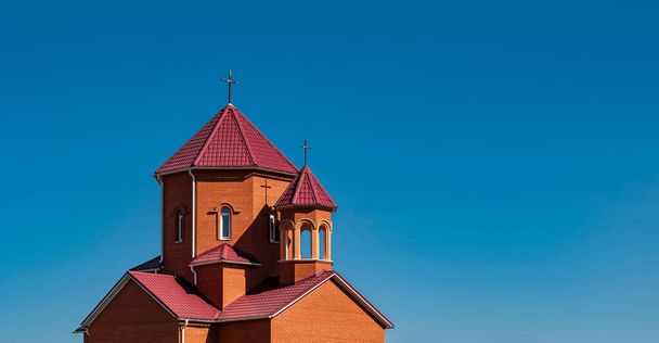 Католическая церковь с крестами на башнях против безоблачного голубого летнего неба
 - Фото, изображение