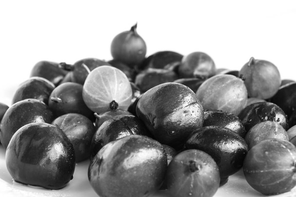 Black and white gooseberries and wild cherry berries (gean) on a light background - Photo, Image
