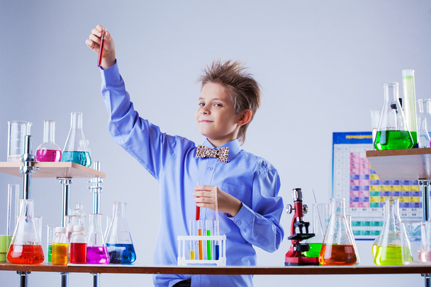 Cute boy posing with variety of reagents in lab - Фото, зображення