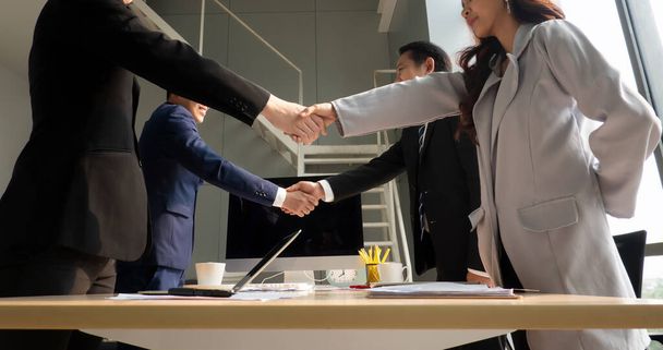 Biznesmeni ściskający dłonie w nowoczesnym biurze kończąc udane spotkanie - Zdjęcie, obraz