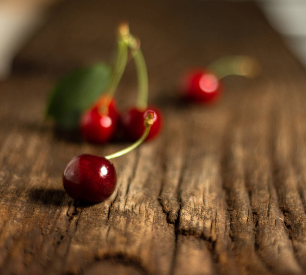 Organic fresh cherries on wet wooden background - Φωτογραφία, εικόνα