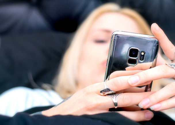 Mulher loira com telefone celular na cama
 - Foto, Imagem