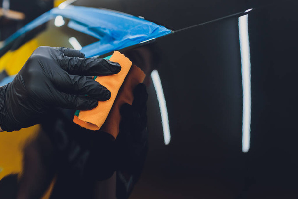 Car detailing - Man applies nano protective coating to the car. Selective focus. - Foto, Imagem