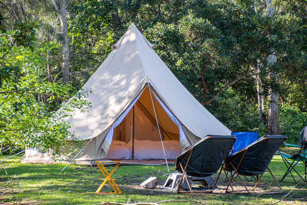 Glamping camping tenda teepee e cadeiras no parque de campismo
. - Foto, Imagem
