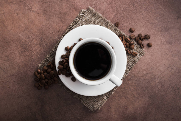 Aroma xícara de café com grãos torrados no fundo antigo vintage, vista superior
 - Foto, Imagem