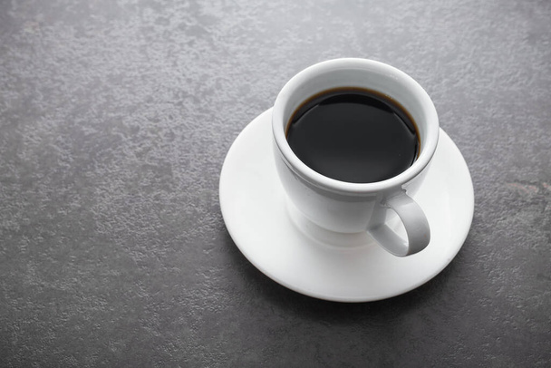 石のテーブルの上に黒いコーヒーと白いセラミックカップ - 写真・画像