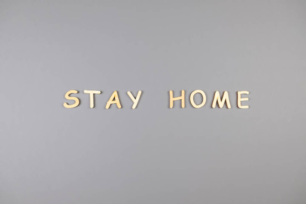 Words stay home made from wooden letters on gray background. Top view - Фото, зображення
