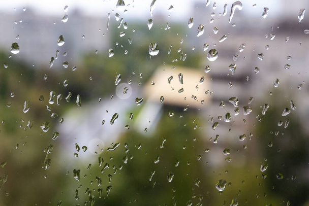 モスクワ(ロシア)で夏の曇りの日。突然の冷たいスナップ、窓ガラスや街並みにドロップします。濡れたガラスの質感. - 写真・画像
