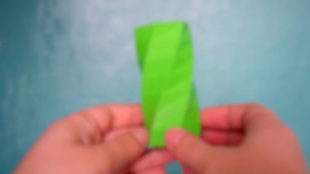 Blurred background. The person holds on hands and view green object - Footage, Video