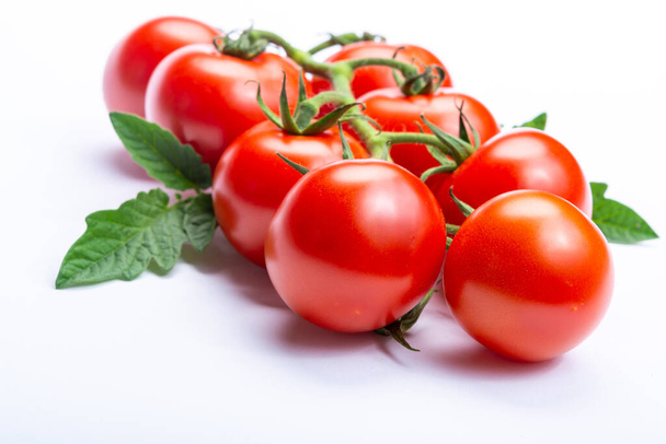 Bündel frischer reifer roter Tomaten mit isolierten Blättern auf weißem Hintergrund Nahaufnahme Kopierraum - Foto, Bild