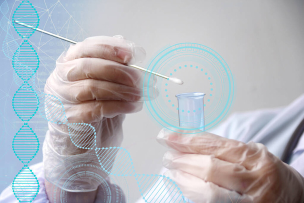laboratory assistant in gloves puts a sample for DNA analysis on a cotton swab in a glass test tube, the concept of scientific and medical examination, close-up - Photo, Image