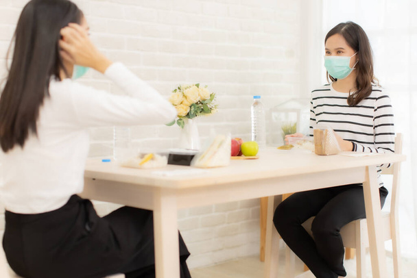 Young Asian  woman sitting separated in restaurant or home  eating food with table protect infection from coronavirus covid-19, new normal restaurant and social distancing concept. - Fotoğraf, Görsel