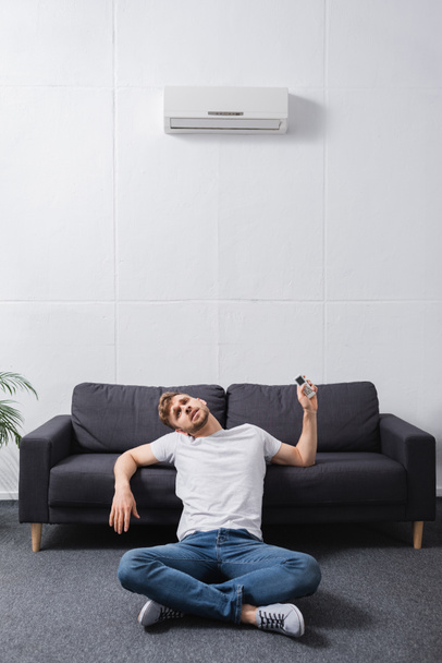 hombre agotado sentirse incómodo con el aire acondicionado roto en casa durante el calor del verano
  - Foto, Imagen