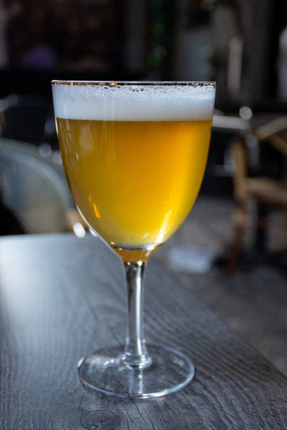 Híres belga sört szolgálnak fel odakint egy kis régi kávézóban, különleges belga sörösüvegben, napfényben. - Fotó, kép