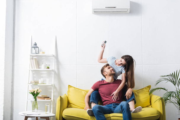 happy emotional couple hugging at home with air conditioner - Valokuva, kuva