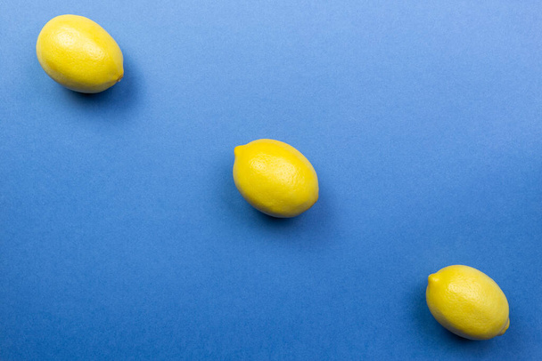 Lemons on the blue background. Flat lay. - Фото, изображение