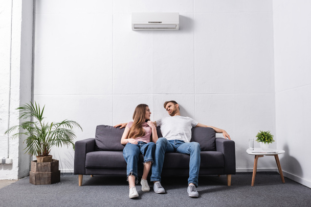 pareja joven que sufre de calor mientras está sentada en casa con el aire acondicionado roto
  - Foto, Imagen