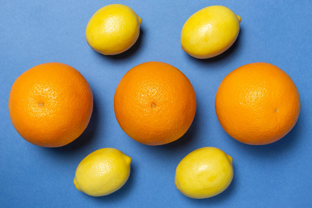 Lemons and oranges on the blue backgruond. Flat lay. - 写真・画像