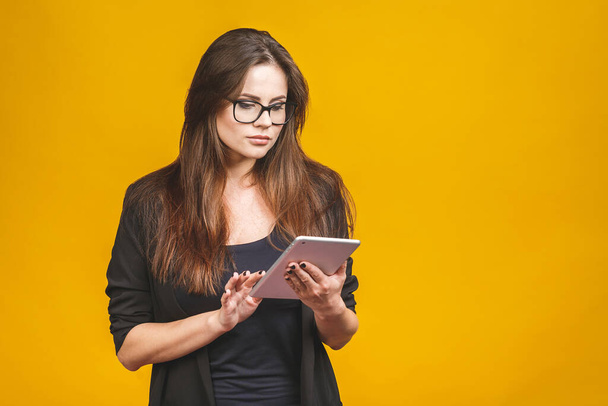 Femme d'affaires tenant un ordinateur tablette isolé sur fond jaune
. - Photo, image