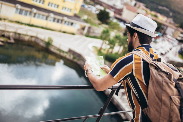 Sırt çantalı yakışıklı sakallı turist şehir boyunca seyahat ediyor..  - Fotoğraf, Görsel