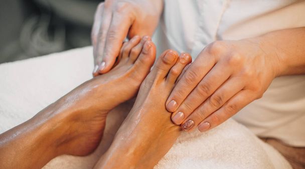 Zamknij zdjęcie białej kobiety mającej sesję masażu stóp w profesjonalnym salonie spa - Zdjęcie, obraz