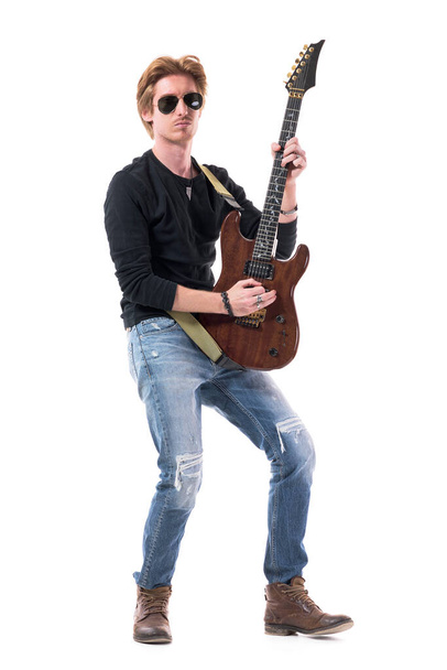 Komoly magabiztos rocker gitáros, aki elektromos gitározik napszemüvegben. Teljes test hossza elszigetelt fehér háttér.  - Fotó, kép