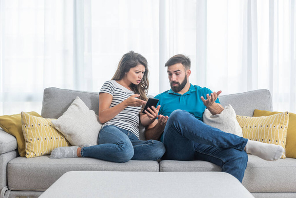 Young couple arguing about text messages on the boyfriends phone where girlfriend is jealous for finding the communication with other girl - Foto, Bild