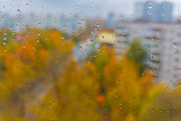 Moskova 'da (Rusya) sonbaharda bulutlu yağmurlu bir gün. Ani soğuk çarpması, cam ve şehir manzarasına damlalar. Islak cam dokusu. - Fotoğraf, Görsel
