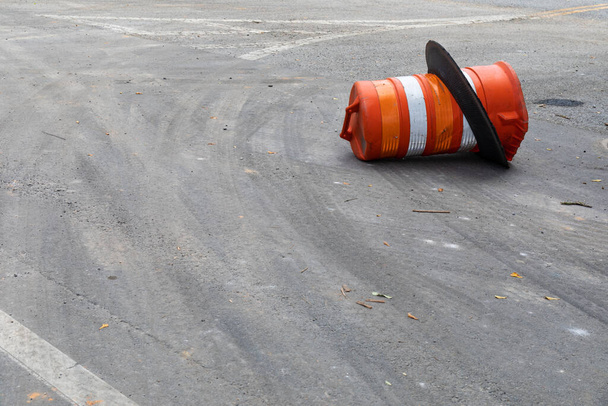 Asfalto superficie de la calle con el barril de tráfico naranja en su lado, seguridad y peligro vial, espacio de copia, aspecto horizontal
 - Foto, imagen